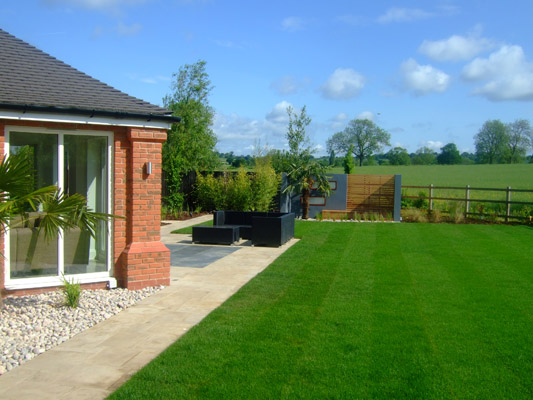large lawn with patio and contemporary garden snug